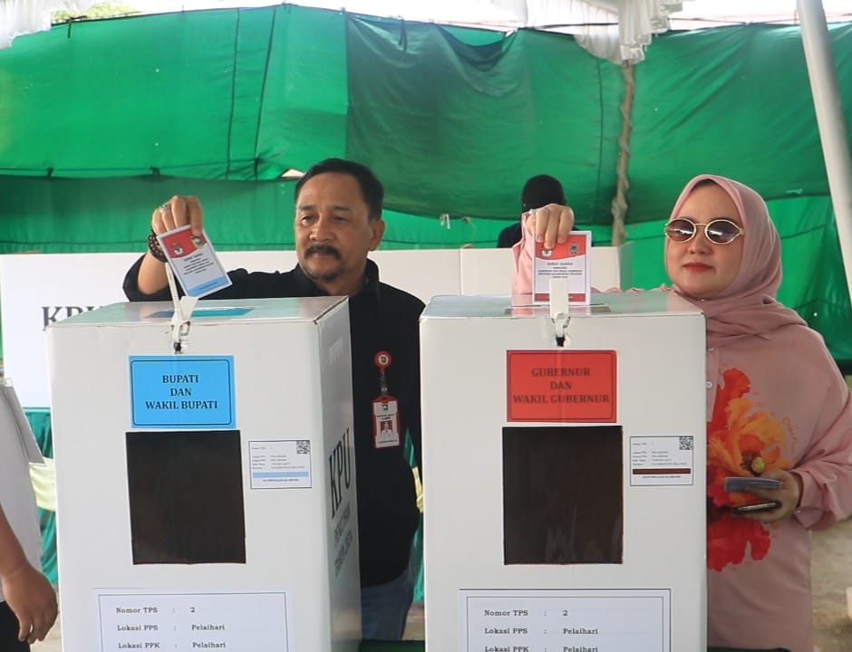 Pj Bupati Tanah Laut, Ir. H. Syamsir Rahman bersama isteri, Hj. Yulia Syamsir Rahman turut menggunakan hak suara di TPS 02 Halamn Kelurahan Pelaihari, Rabu (27/11). Foto: siberdbn.com-Can