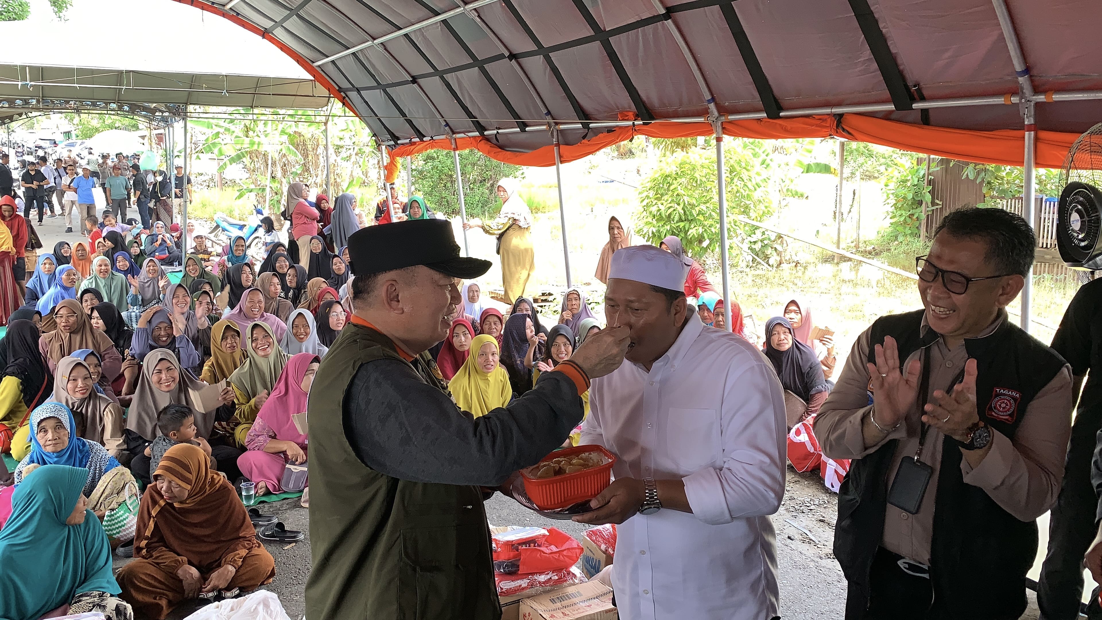 H Bahrul Ilmi saat menerima suapan dari gubernur Kalsel H Muhidin saat mencicipi makanan cepat saji bantuan Kemensos RI untuk korban banjir, Sabtu (25/1/2025). Foto: san/siberdbn.com