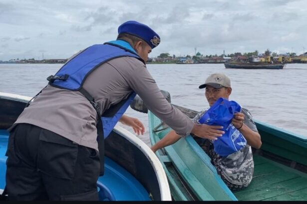 Teks Foto: Anggota Sat Polairud Polresta Banjarmasin bagikan sembako kepada pengguna jasa perairan, Jum'at (10/1/2025). Foto: Humas Polresta Banjarmasin