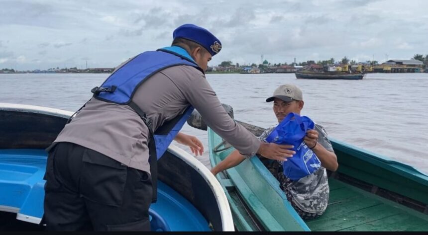 Teks Foto: Anggota Sat Polairud Polresta Banjarmasin bagikan sembako kepada pengguna jasa perairan, Jum'at (10/1/2025). Foto: Humas Polresta Banjarmasin