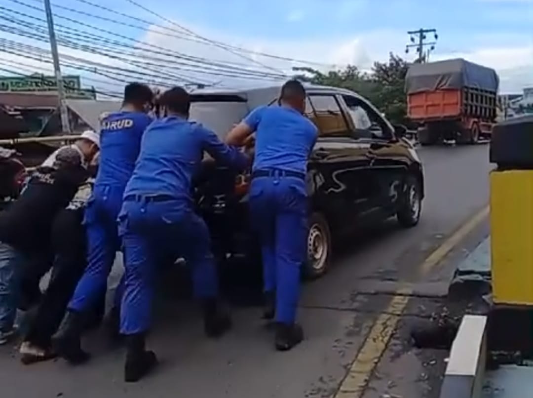 Teks Foto: Personel Sat Polairud Polresta Banjarmasin dan relawan haul membantu mendorong mobil Jemaah yang mogok, Selasa (25/2/2025). Foto: siberdbn.com/Riana